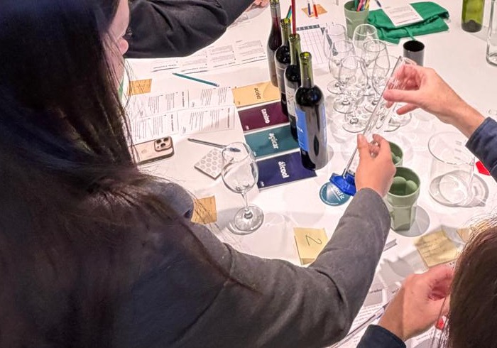 Mãos montando o próprio blend de vinho no Wine Lab da Feel It